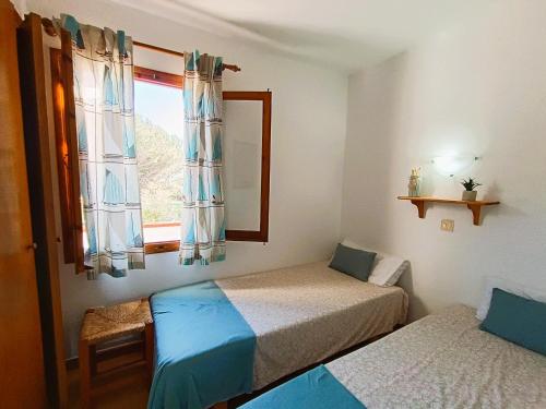 Habitación con 2 camas y ventana en Apartamentos Sol Isla en Arenal d'en Castell