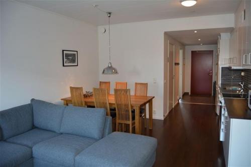 a living room with a blue couch and a wooden table at Funäs Ski Lodge in Funäsdalen