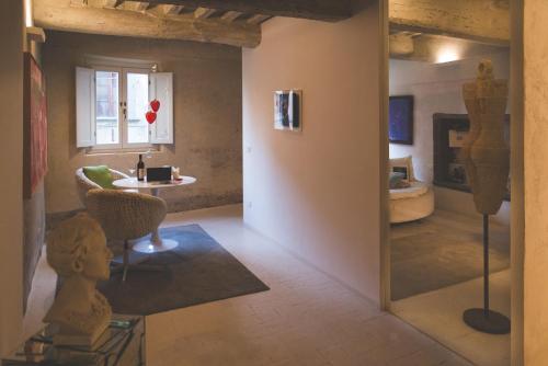 Santa Maria a MonteにあるART SUITE GALLERY - Tuscany - medieval town close to Florence, Pisa, Lucca, Chianti Zone, Versiliaのリビングルーム(テーブル、椅子付)が備わる客室です。