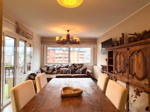 uma sala de jantar com uma mesa e um sofá em Apartament Les Vernedes em Sort