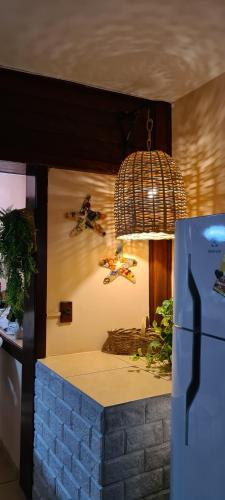 a kitchen with a counter with a refrigerator and a chandelier at Red Rose in Cabo Frio