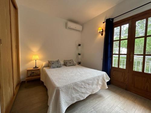 a bedroom with a bed and a large window at Villa Son Serra de Marina in Son Serra de Marina
