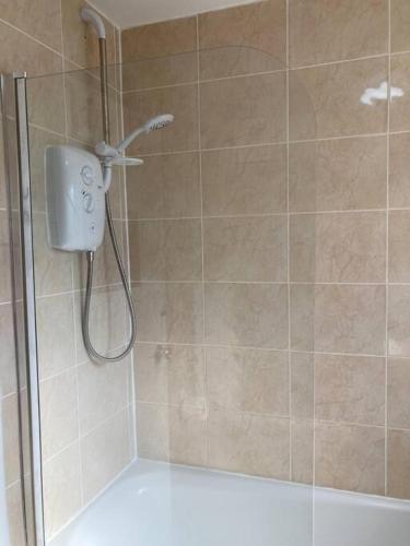 a shower with a shower head in a bathroom at Comfy 1 bedroom flat with free parking in Glasgow
