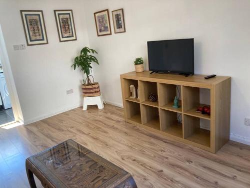 a living room with a flat screen tv on a shelf at Comfy 1 bedroom flat with free parking in Glasgow