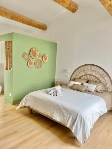 Un dormitorio con una cama grande con dos animales de peluche. en CHAMBRE d'Hôtes avec PISCINE & KITCHENETTE en Saint-Geniès-des-Mourgues