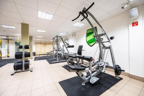 a gym with several tread machines in a room at Hotel Club Tisza in Lakitelek