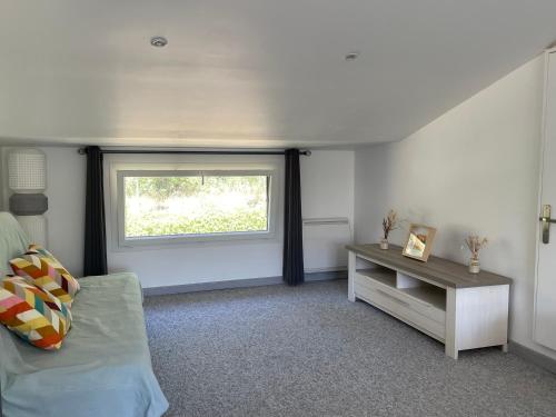 Zimmer mit einem Fenster, einem Sofa und einem Tisch in der Unterkunft Le Domaine de Jaïna in Le Beausset