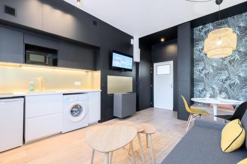 une cuisine et un salon avec une table et des chaises dans l'établissement Marcq-en-Baroeul - beautiful fully equipped ! 2p, à Marcq-en-Barœul