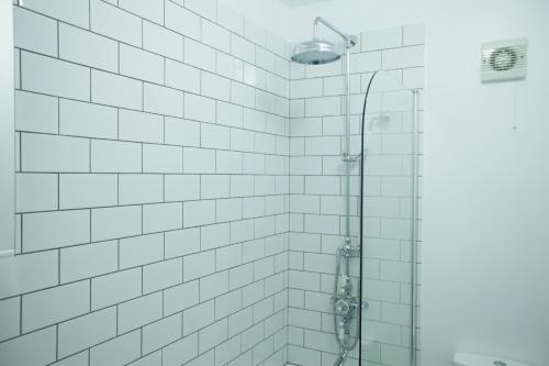 a bathroom with a shower with white tiled walls at Richmond Modern Apartment in Richmond upon Thames