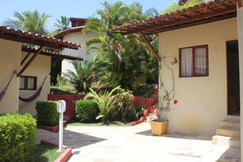 a courtyard of a house with trees and plants at Pousada Corais do Sul in Pipa