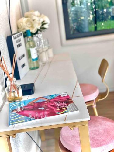 a table with a book sitting on top of it at Delightful little house & Chateau Charme Suite in Auckland