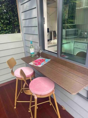 a table and two chairs sitting on a porch at Delightful little house & Chateau Charme Suite in Auckland