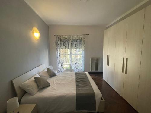 um quarto com uma cama branca e uma janela em G&G Giusy e Gabry em Santhià