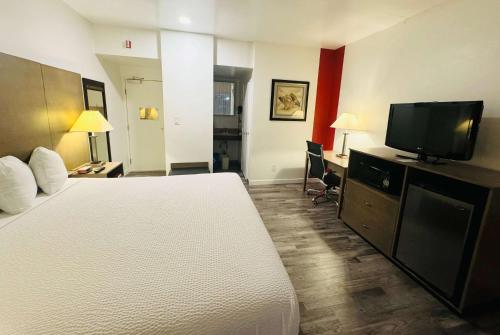 a hotel room with a bed and a flat screen tv at Ramada by Wyndham San Diego Airport in San Diego