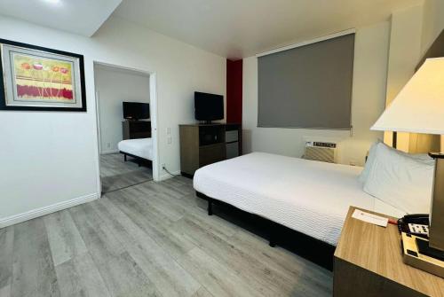 a hotel room with a bed and a flat screen tv at Ramada by Wyndham San Diego Airport in San Diego