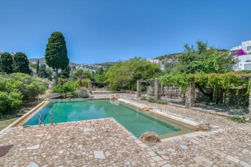 a swimming pool in a yard with trees and a building at Lefkes Village Living in Lefkes