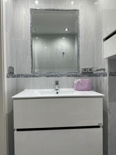 a bathroom with a white sink and a mirror at Apartamento turístico O.N Renfe in Córdoba