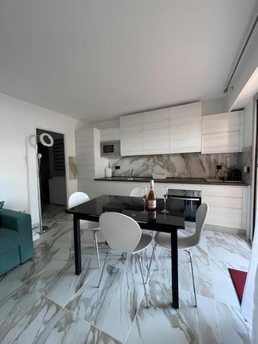 a kitchen with a black table and white chairs at Andrea's holydays in Roquebrune-Cap-Martin