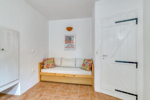 a white hallway with a bench in a room at Lefkes Village Living in Lefkes