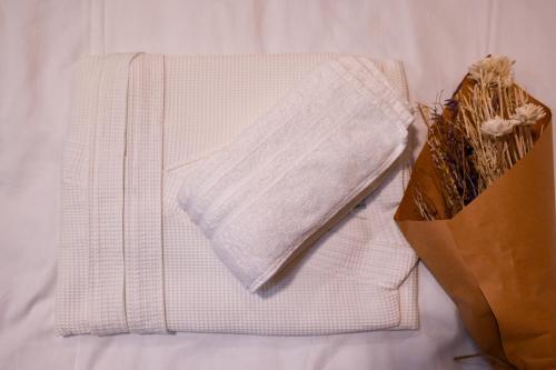 a white towel and a bag on a bed at VAL HILLS Rural Holiday House in Gaj Vrbovečki