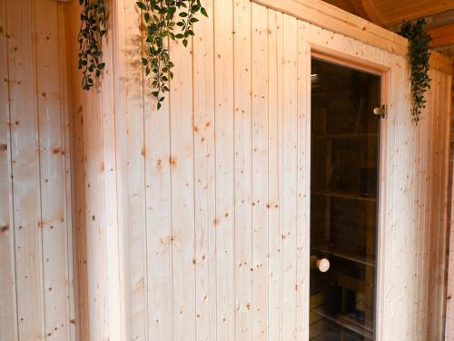 a wooden wall with a door and ivy on it at VAL HILLS Rural Holiday House in Gaj Vrbovečki