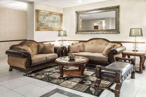 a living room with leather furniture and a mirror at Baymont by Wyndham Tyler in Tyler