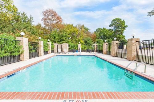 ein Bild eines Pools mit einem Zaun in der Unterkunft Grander Inn & Suites in Tyler