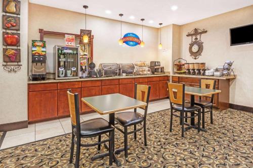 ein Restaurant mit Tischen und Stühlen und einer Theke in der Unterkunft Grander Inn & Suites in Tyler