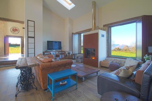 a living room with couches and a fireplace at Casona Alto Sarracin in Penagos