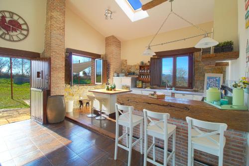 cocina con taburetes blancos y mesa en una habitación en Casona Alto Sarracin, en Penagos