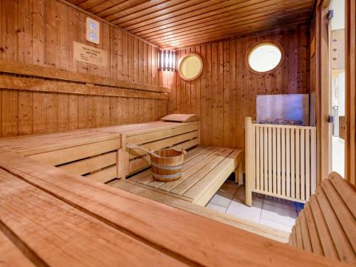 an empty wooden sauna with a bucket in it at Mercure Hotel Duisburg City in Duisburg