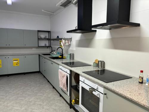 a large kitchen with white counters and appliances at Onefam Les Corts in Barcelona