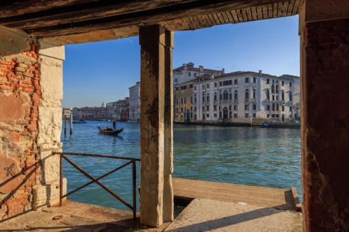 een uitzicht op een kanaal met een boot in het water bij Ca' Emo Palazzo sul Canal Grande in Venetië