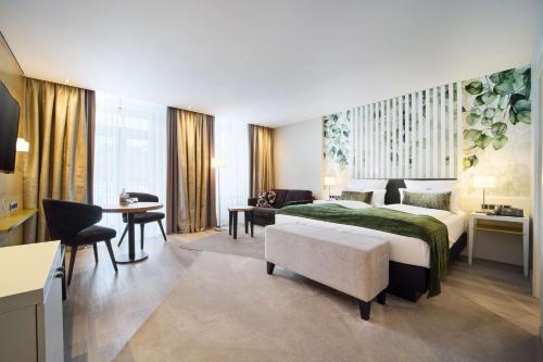 バート・リップシュプリンゲにあるベスト ウェスタン プレミア パーク ホテル ＆ スパのベッドとデスクが備わるホテルルームです。