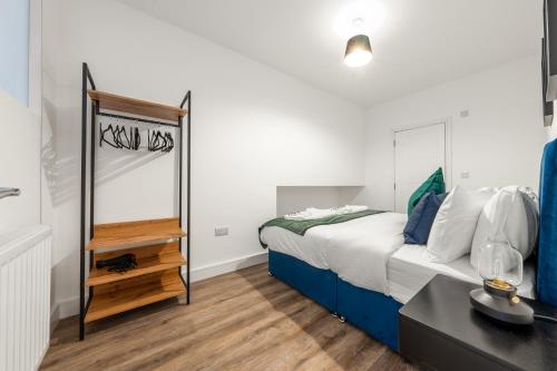 a bedroom with a bed with a mirror and a table at The Hertfordshire Hideaway in Potters Bar