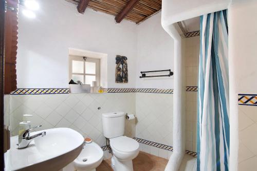 y baño con aseo blanco y lavamanos. en Casa Delfim - Casa Azul, en Alte