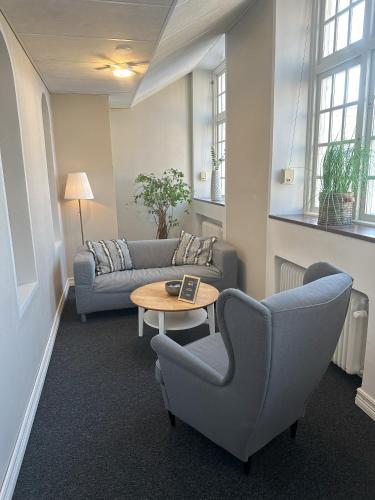 a living room with a couch and a table and chairs at Furunäset Hotell & Konferens in Piteå