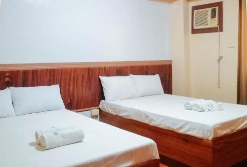 Dos camas en una habitación de hotel con toallas. en RedDoorz @ Farm Side Hotel Laoag City en Laoag