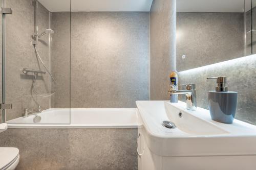 een badkamer met een wastafel en een douche bij The Hertfordshire Hideaway in Potters Bar