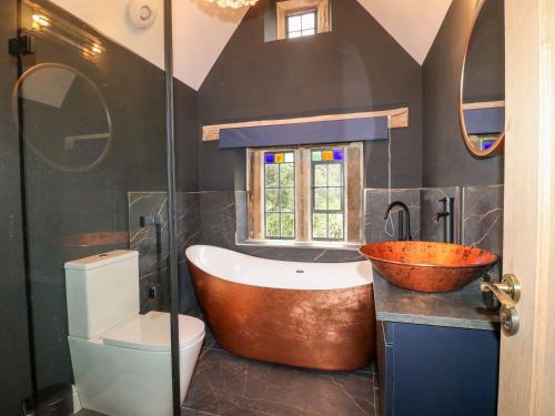 a bathroom with a tub and a toilet and a sink at Wildersley Farm - The Farm House in Belper