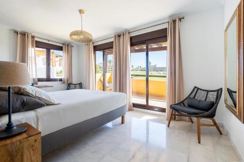 a bedroom with a bed and a chair and windows at VILLA WITH 4 BEDROOMS AND PRIVATE HEATED POOL in San Miguel de Abona
