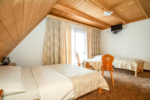 a bedroom with two beds and a window at Willa Pod Orłem Jacuzzi Sauna in Kościelisko