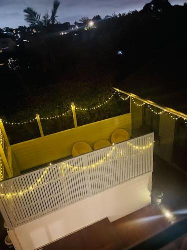 a balcony with chairs and lights at night at Delightful little house & Chateau Charme Suite in Auckland