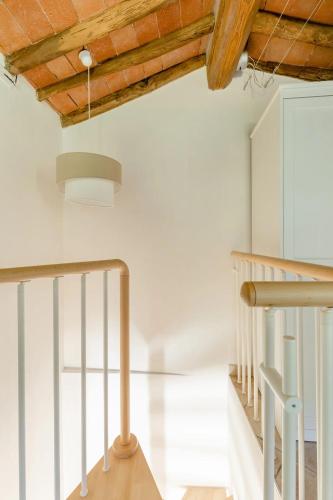 a staircase in a house with a wooden ceiling at Casal delle Rondini in Lucca