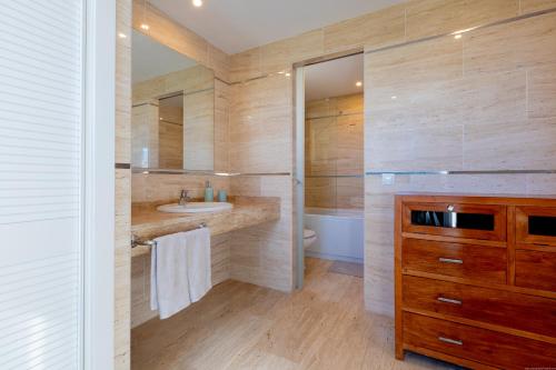 a bathroom with a sink and a toilet and a mirror at VILLA WITH 4 BEDROOMS AND PRIVATE HEATED POOL in San Miguel de Abona