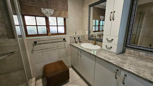 a bathroom with a sink and a mirror at Pont de Fleur in Hartbeespoort