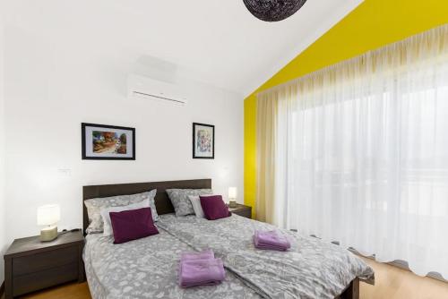 een slaapkamer met een groot bed met paarse kussens bij Villa Fantasia by Istrialux in Hreljići