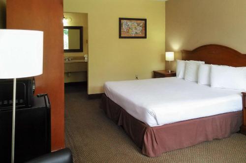 a hotel room with a large bed and a bathroom at Econo Lodge in Ormond Beach