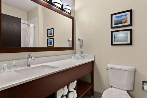 a bathroom with a sink and a toilet and a mirror at Comfort Suites University Las Cruces in Las Cruces