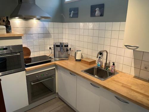 a kitchen with a sink and a counter top at De Maecht van Mechelen in Zierikzee